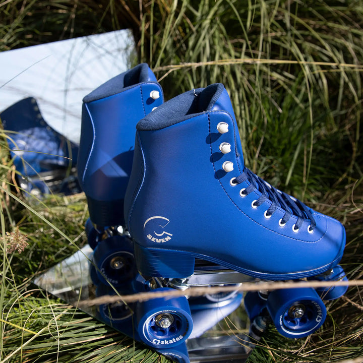 Blue roller skates with white laces on grass