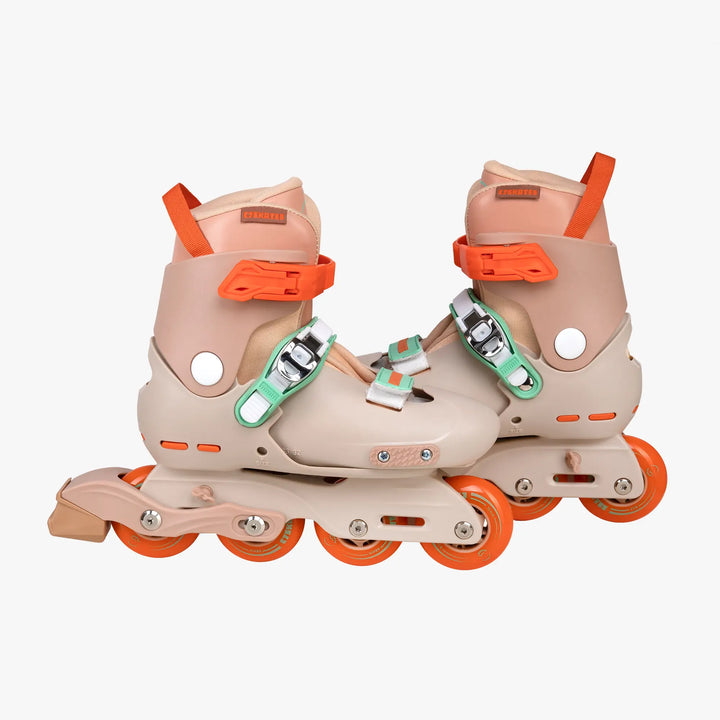 Pair of beige roller skates with orange accents on a white background