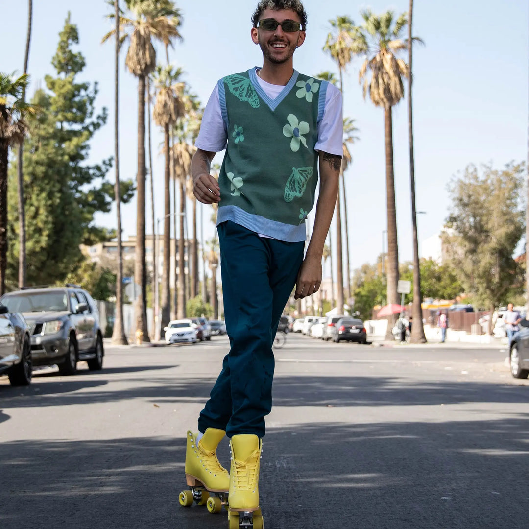 Man rollerblading on a street with palm trees in the background