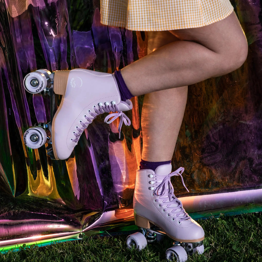 Person wearing white roller skates with a colorful background