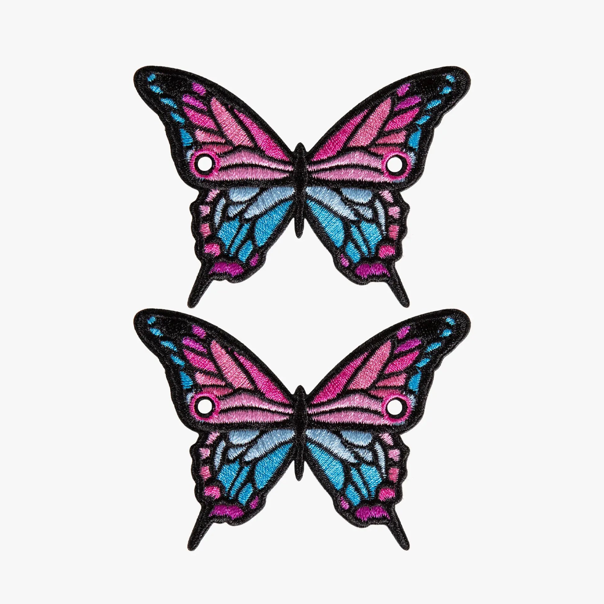 Two butterfly-shaped charms with pink and blue wings on a white background