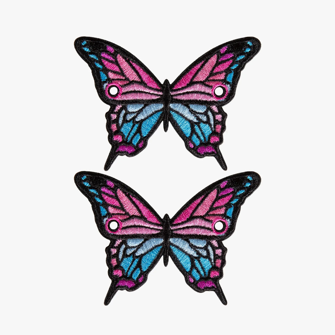 Two butterfly-shaped laces charms with pink and blue wings on a white background