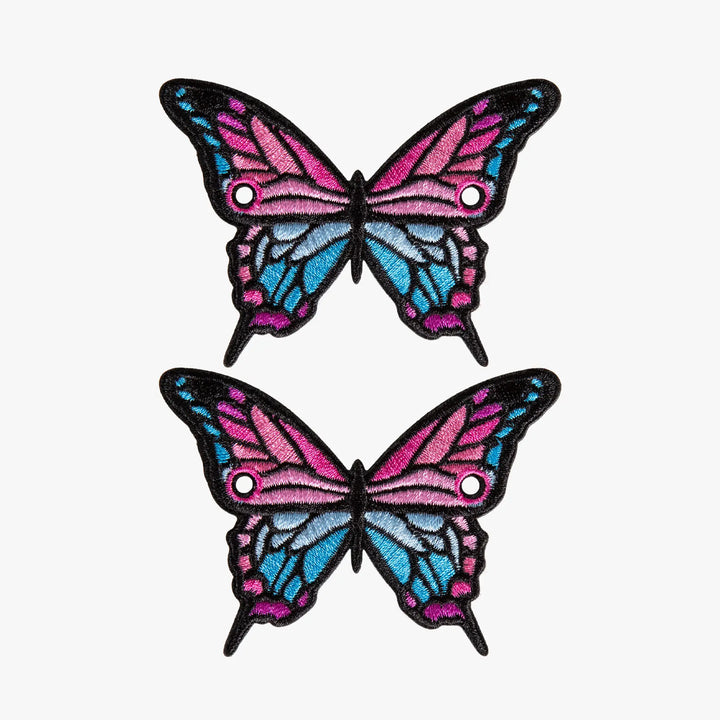 Two butterfly-shaped laces charms with pink and blue wings on a white background