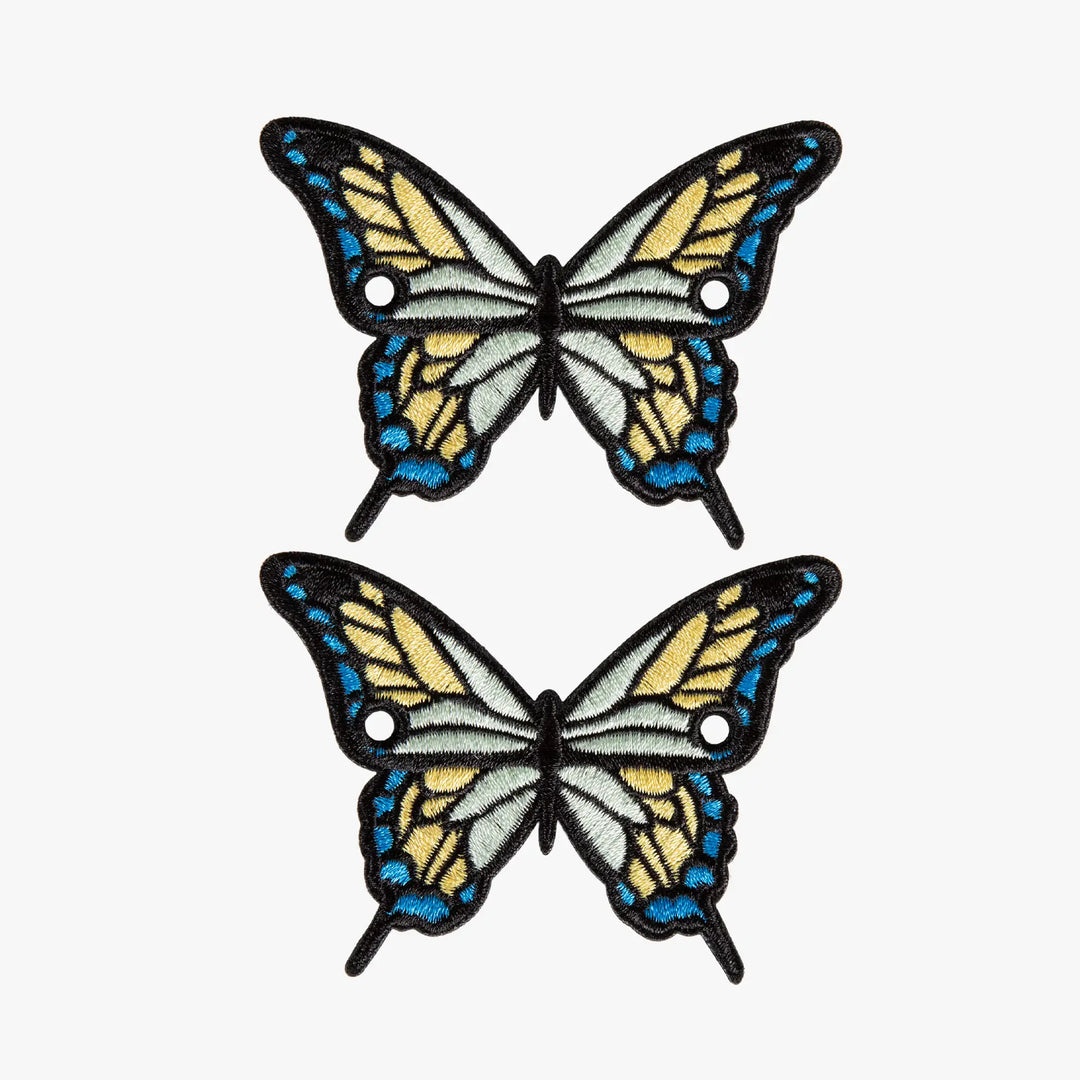 Two butterfly charms with blue and yellow wings on a white background