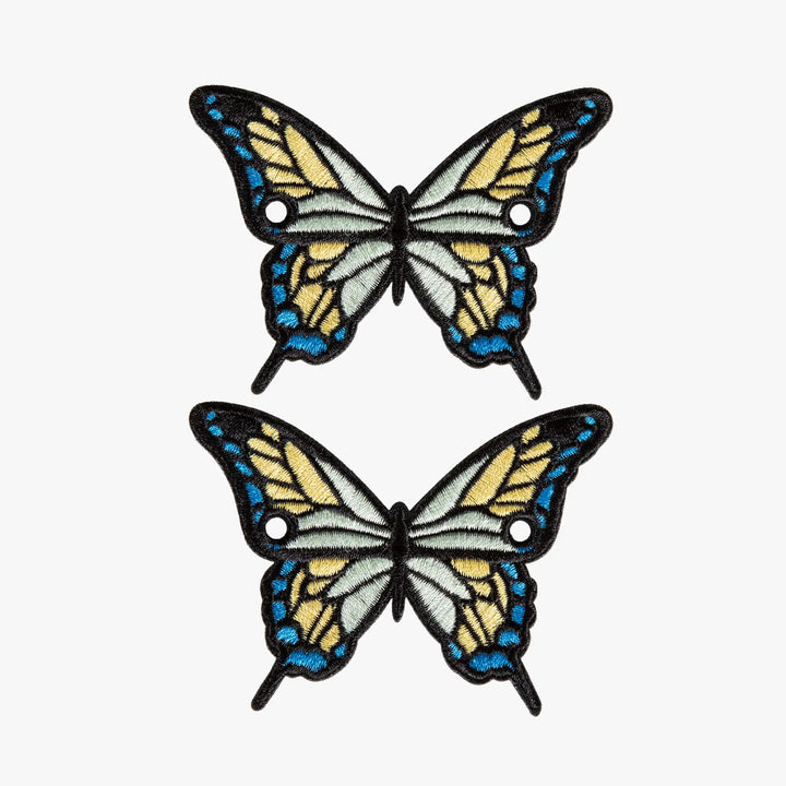 Two butterfly charms with blue and yellow wings on a white background