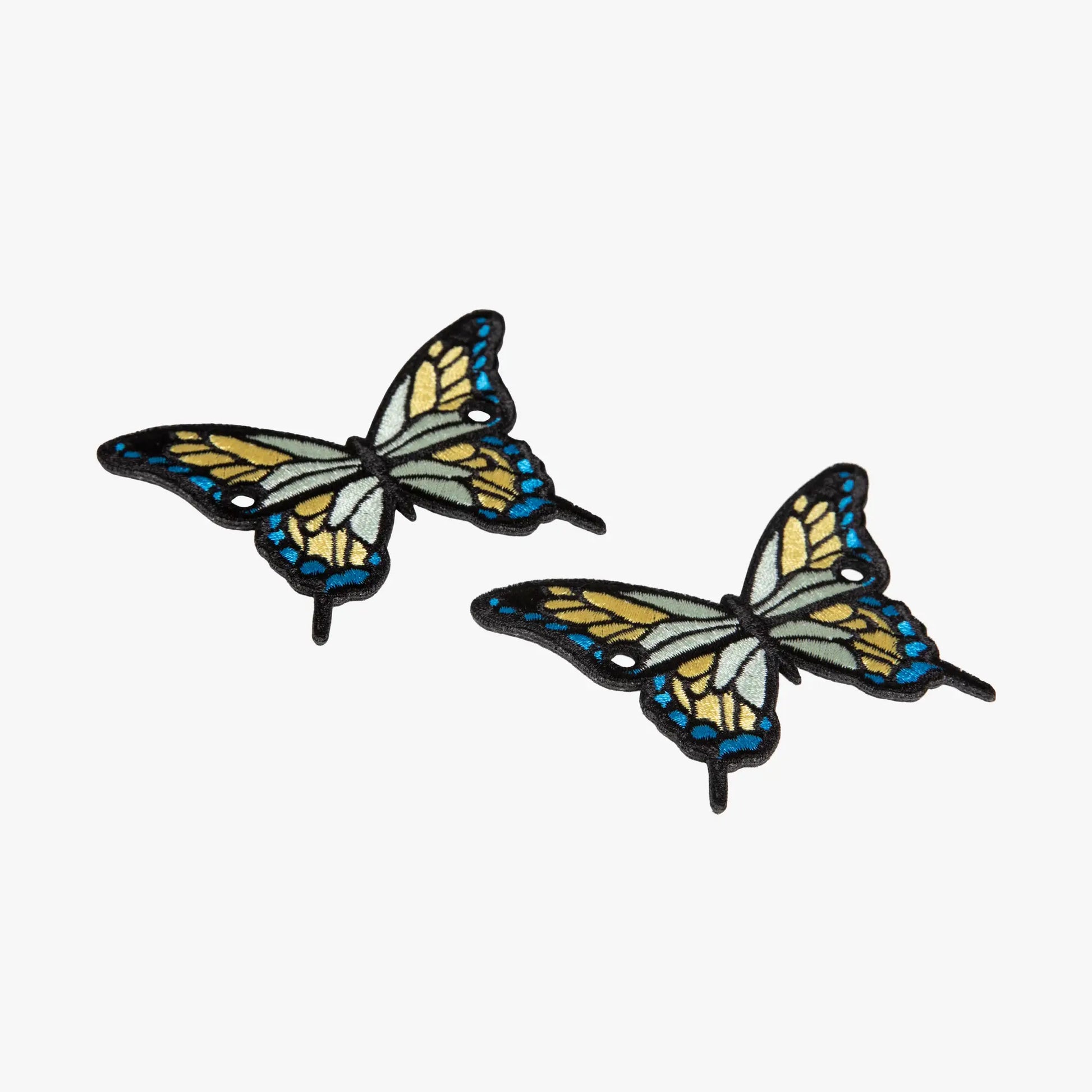 Two butterfly-shaped charms on a white background