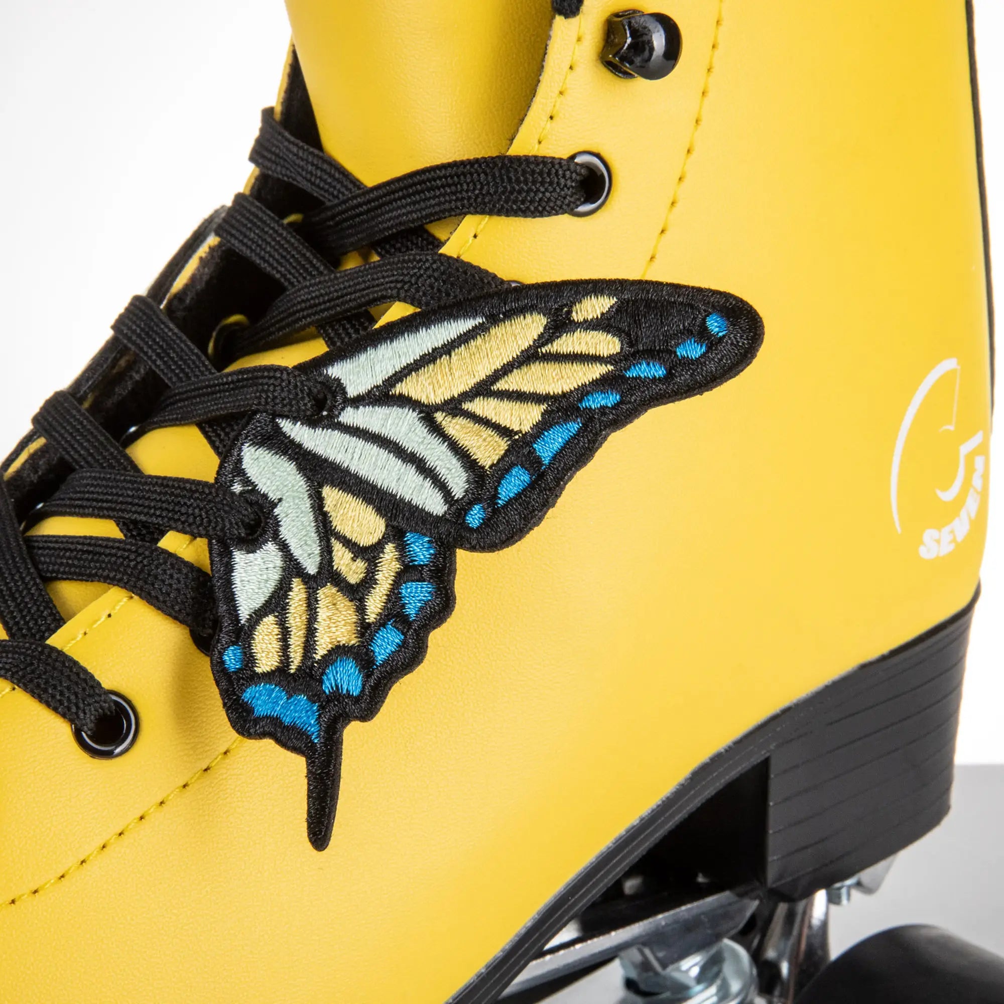 Yellow roller shoe with a butterfly patch and black laces on a white background