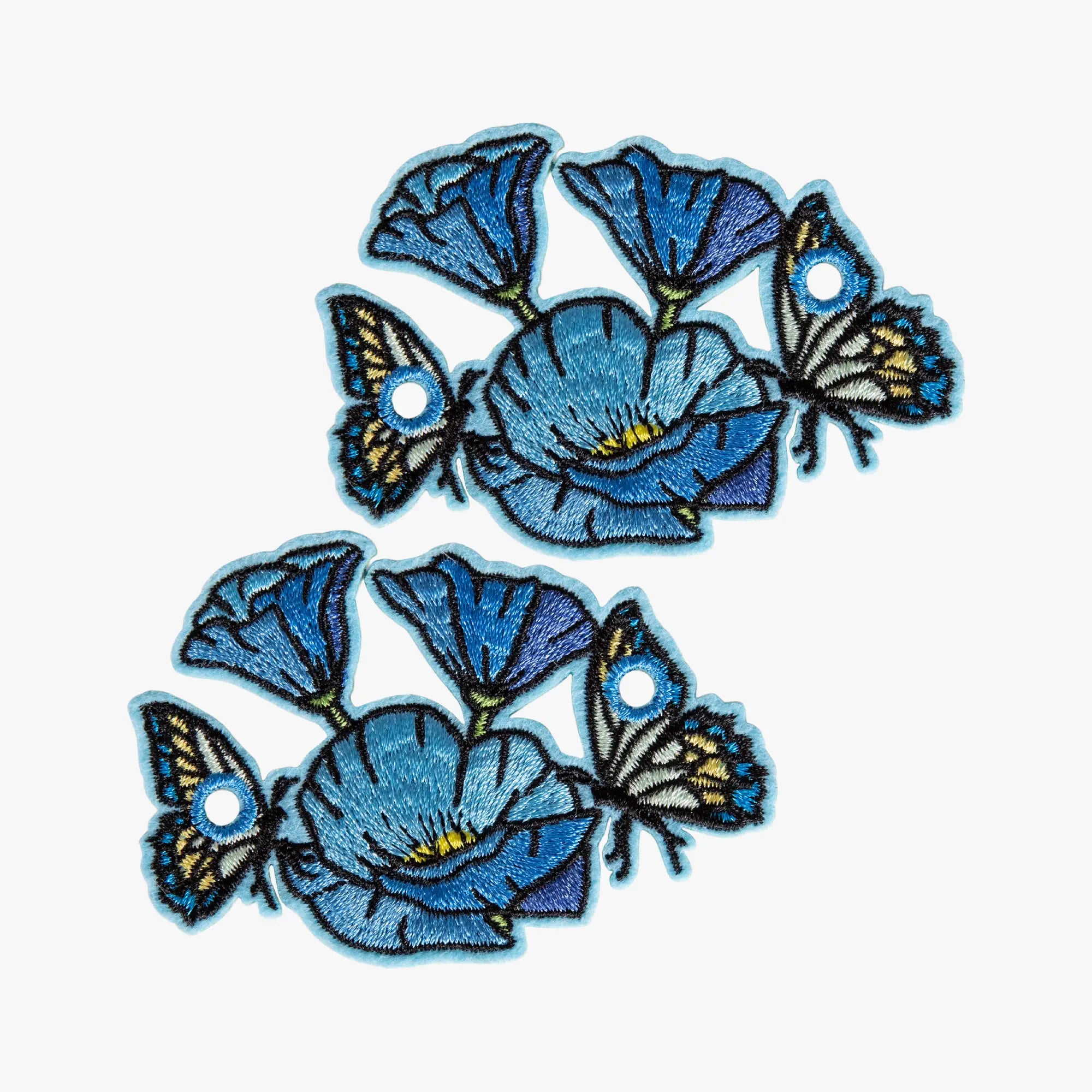 Embroidered charms of blue flowers and butterflies on a white background