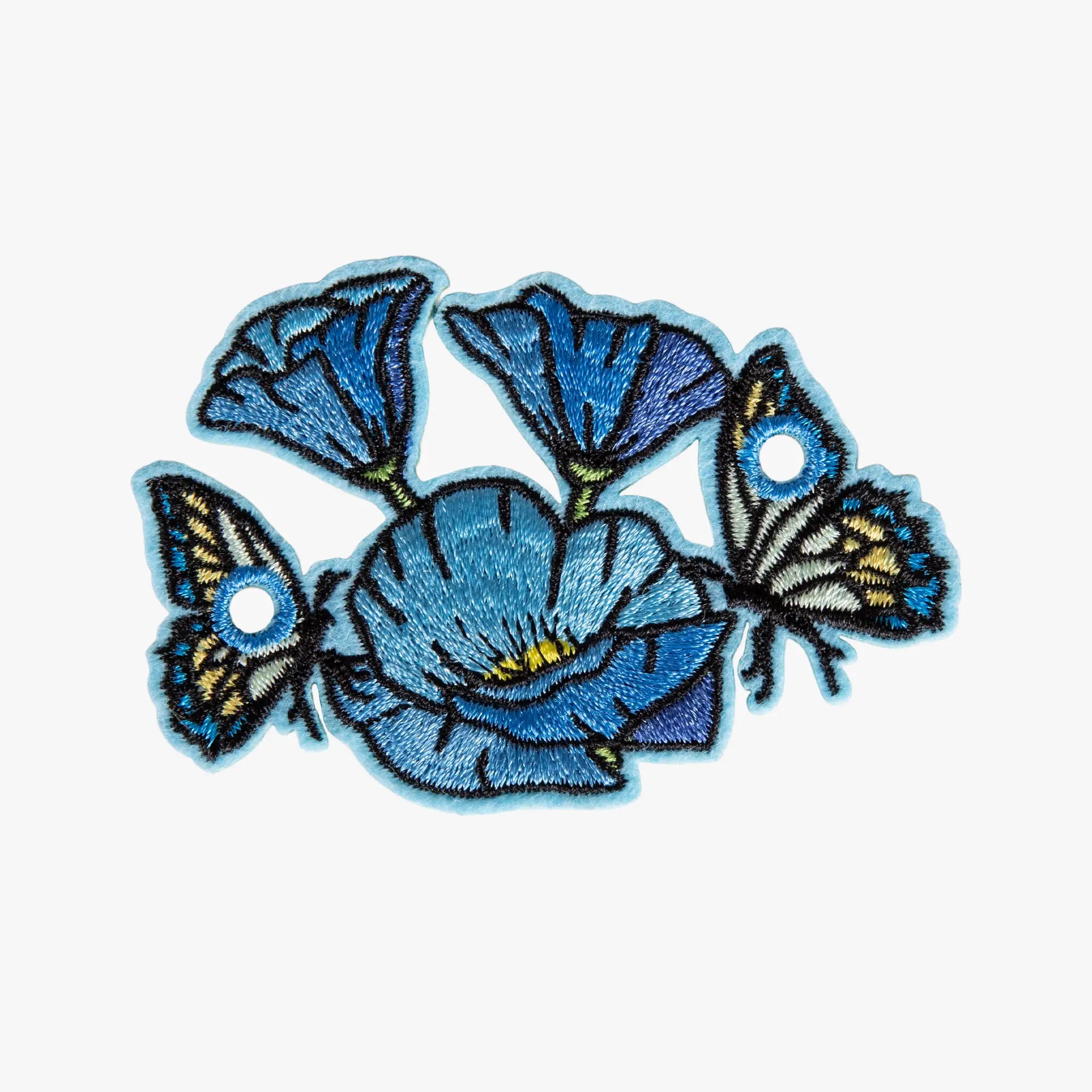 Embroidered charm with blue butterfly design on a white background