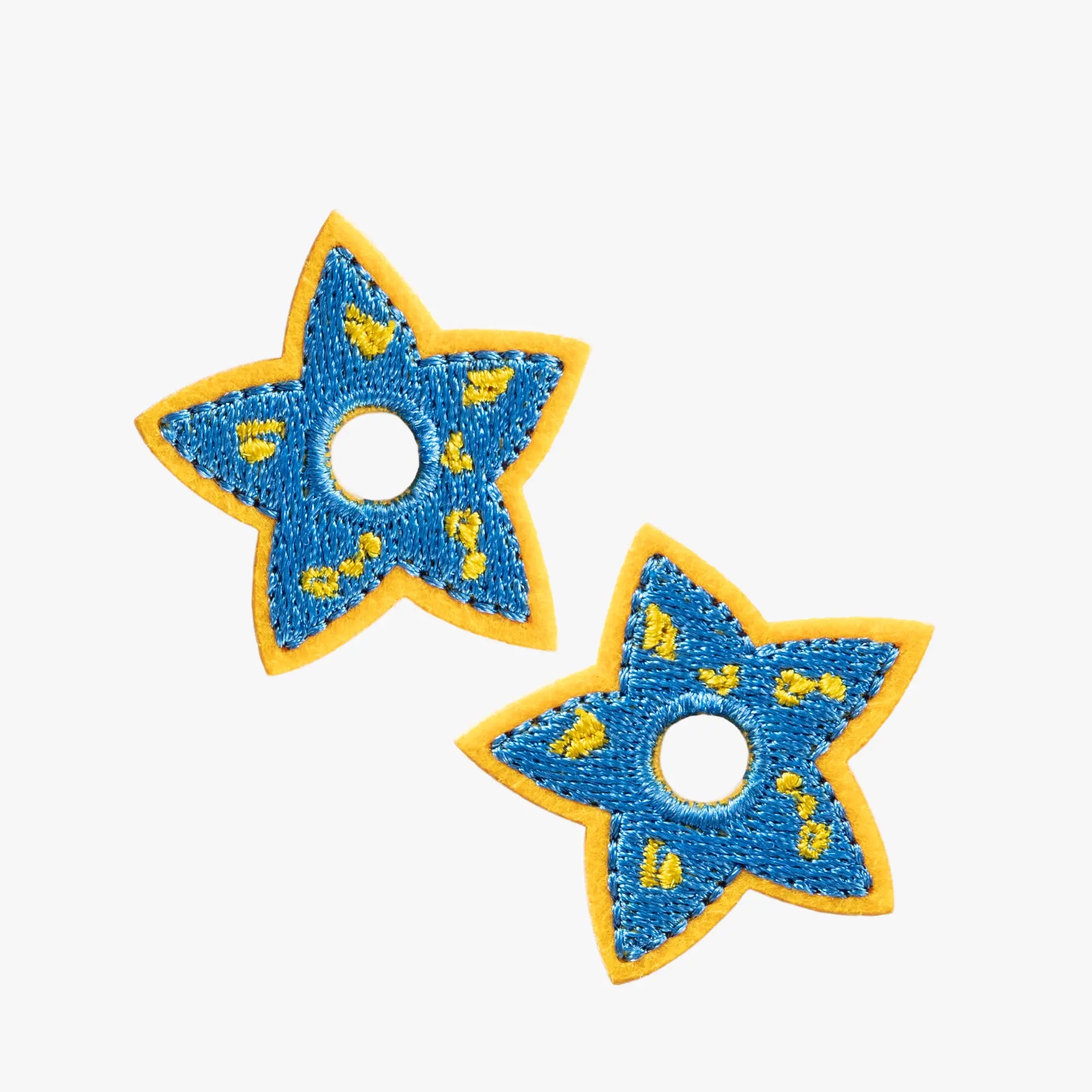 Two blue star-shaped charms with yellow accents on a white background