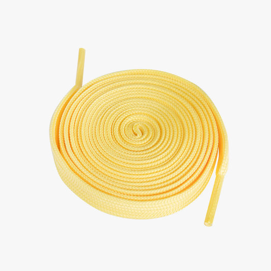 Yellow shoelaces coiled on a white background