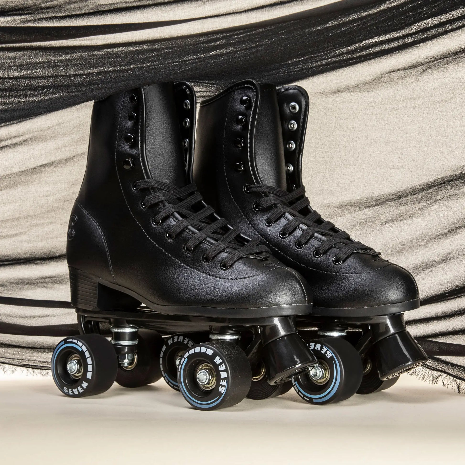 Pair of black roller skates on a neutral background