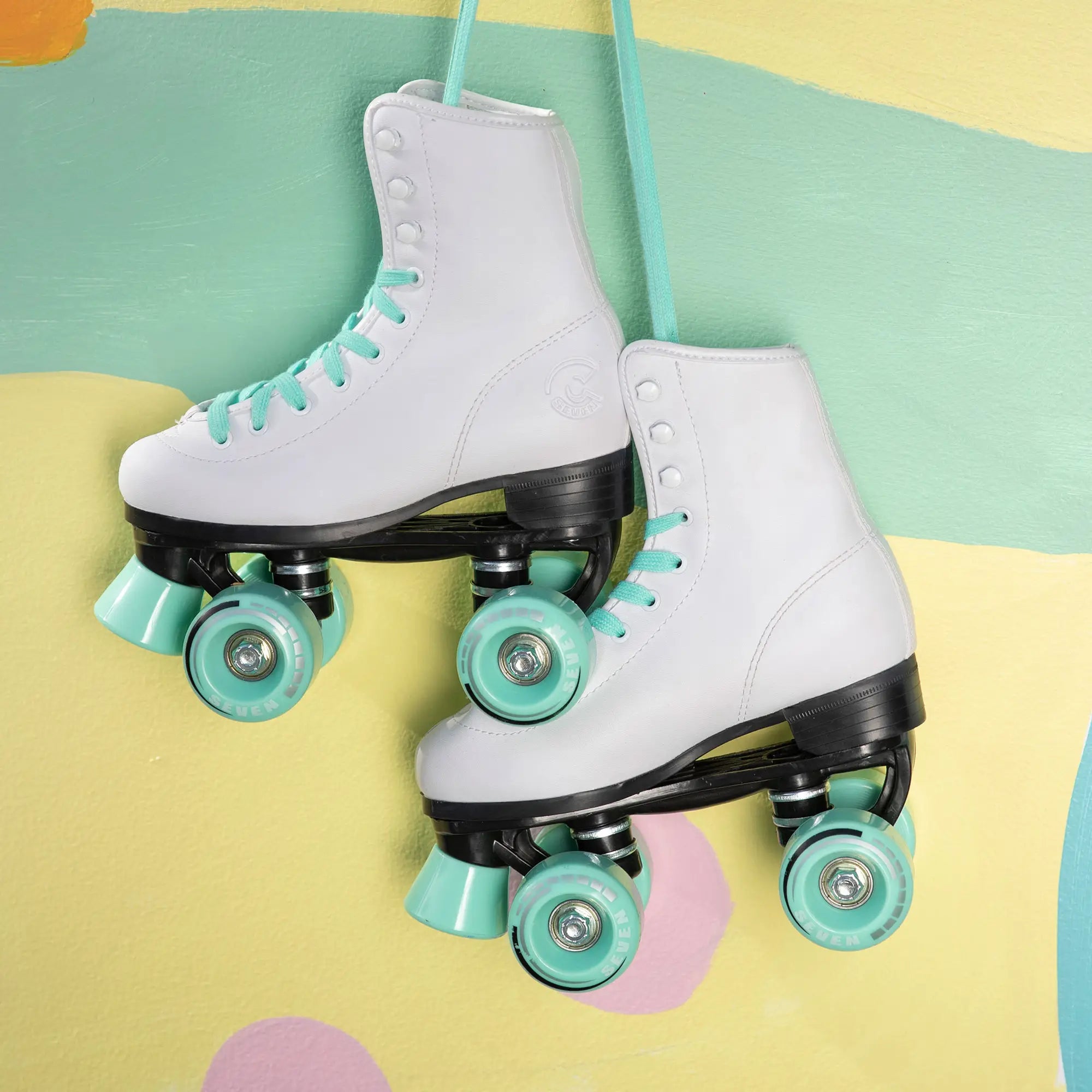 White roller skates with turquoise wheels on a colorful background
