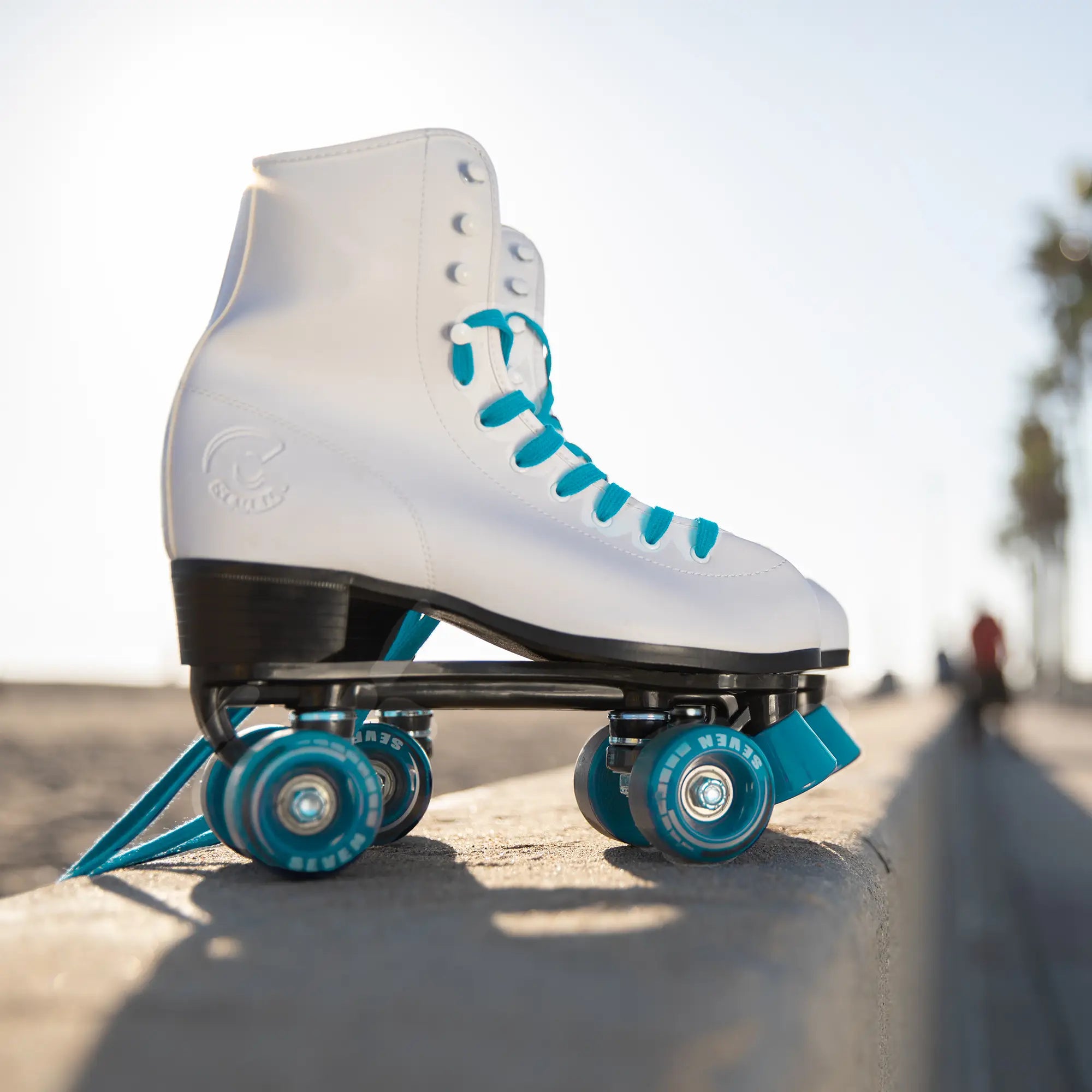 White roller skate with blue wheels on a concrete surface