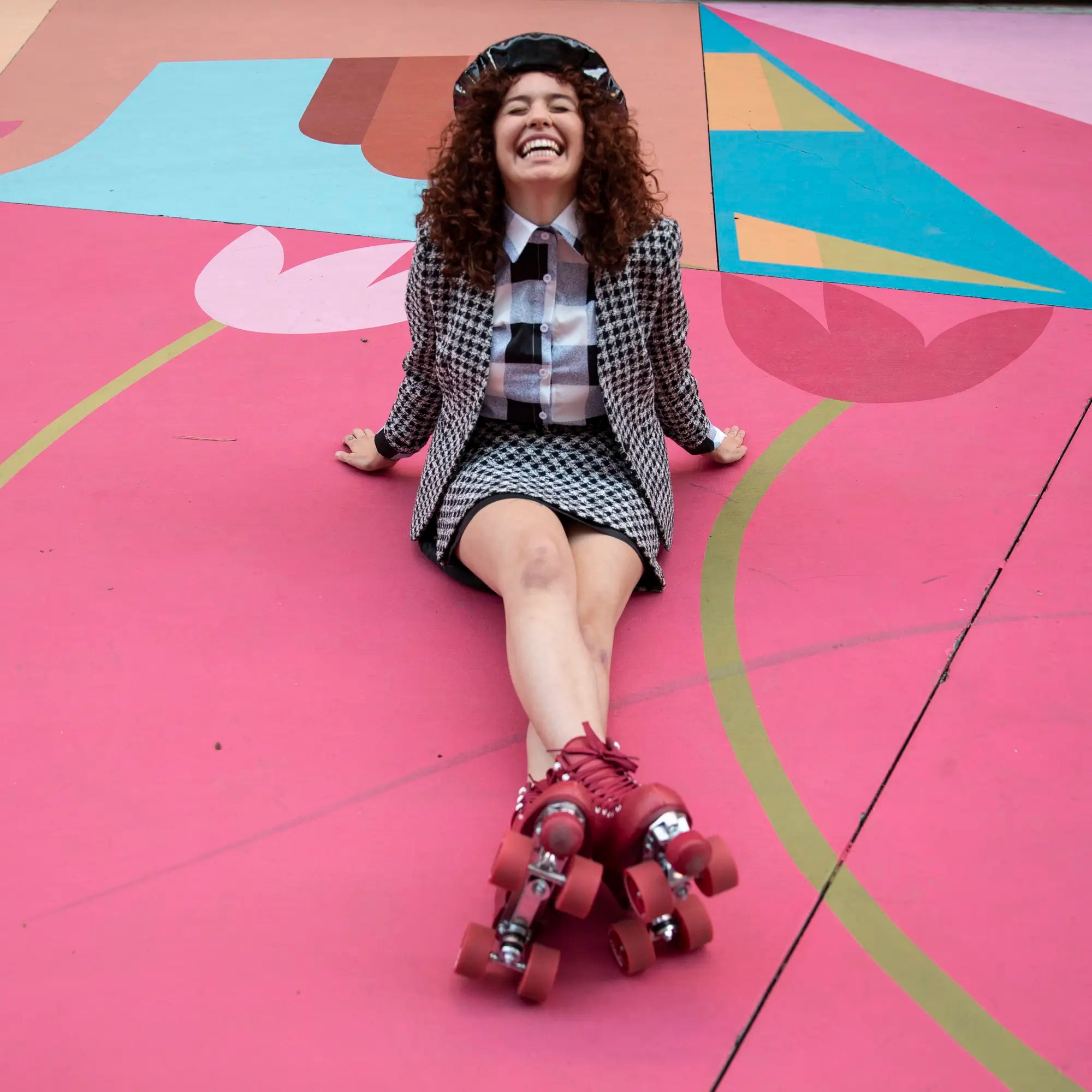 Person wearing roller skates and a checkered outfit on a colorful floor.