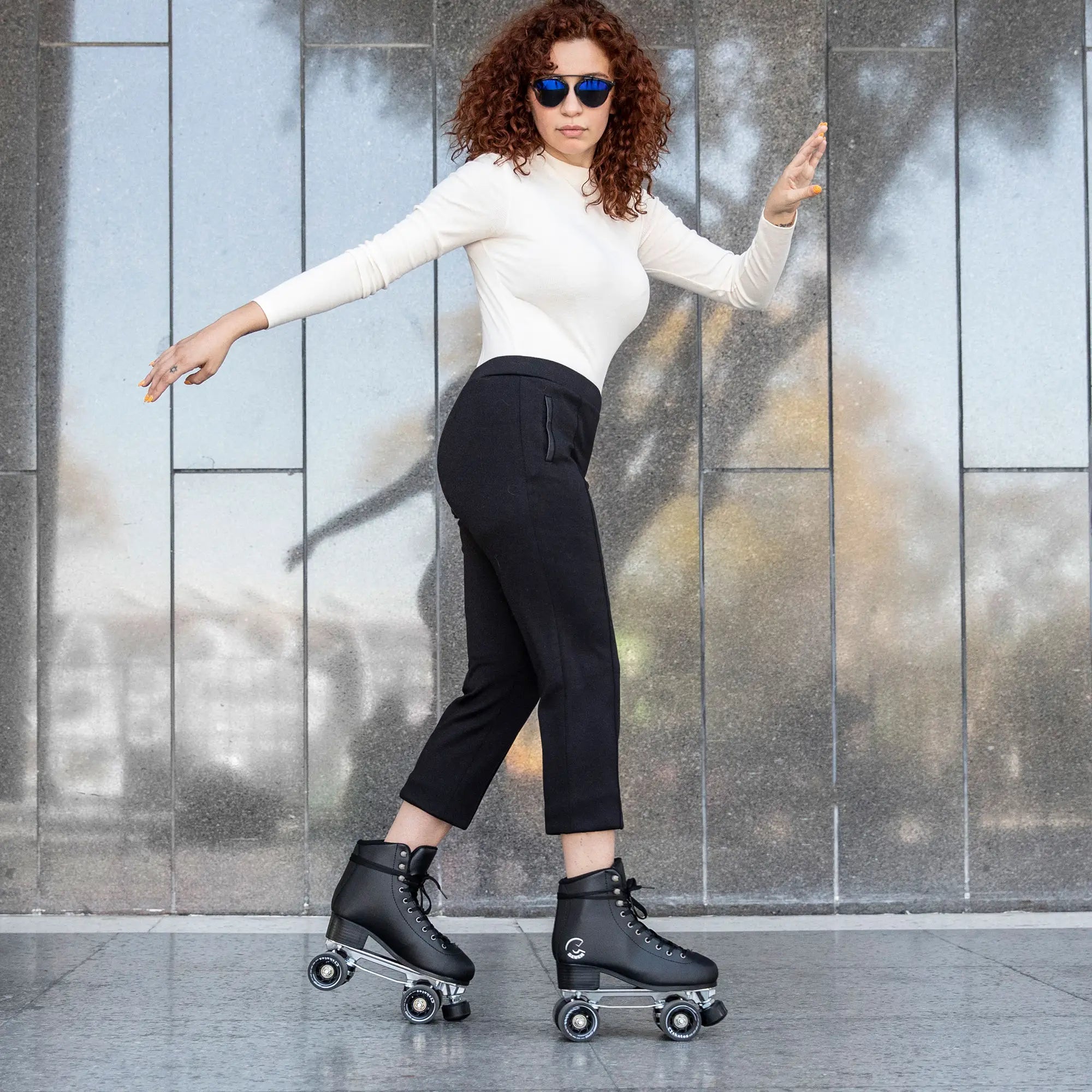 Woman roller skating in front of a textured wall