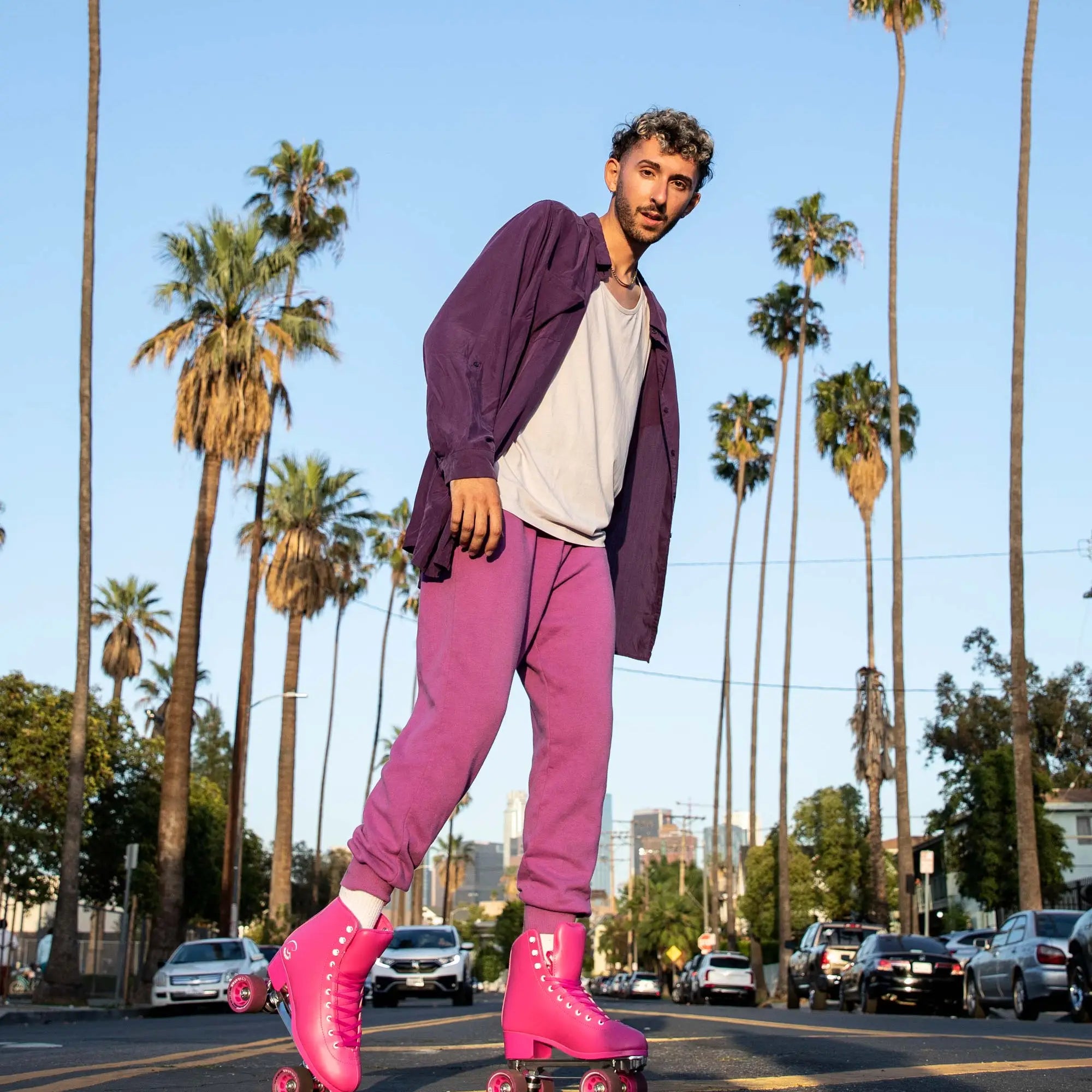 Person rollerblading on a street with palm trees in the background