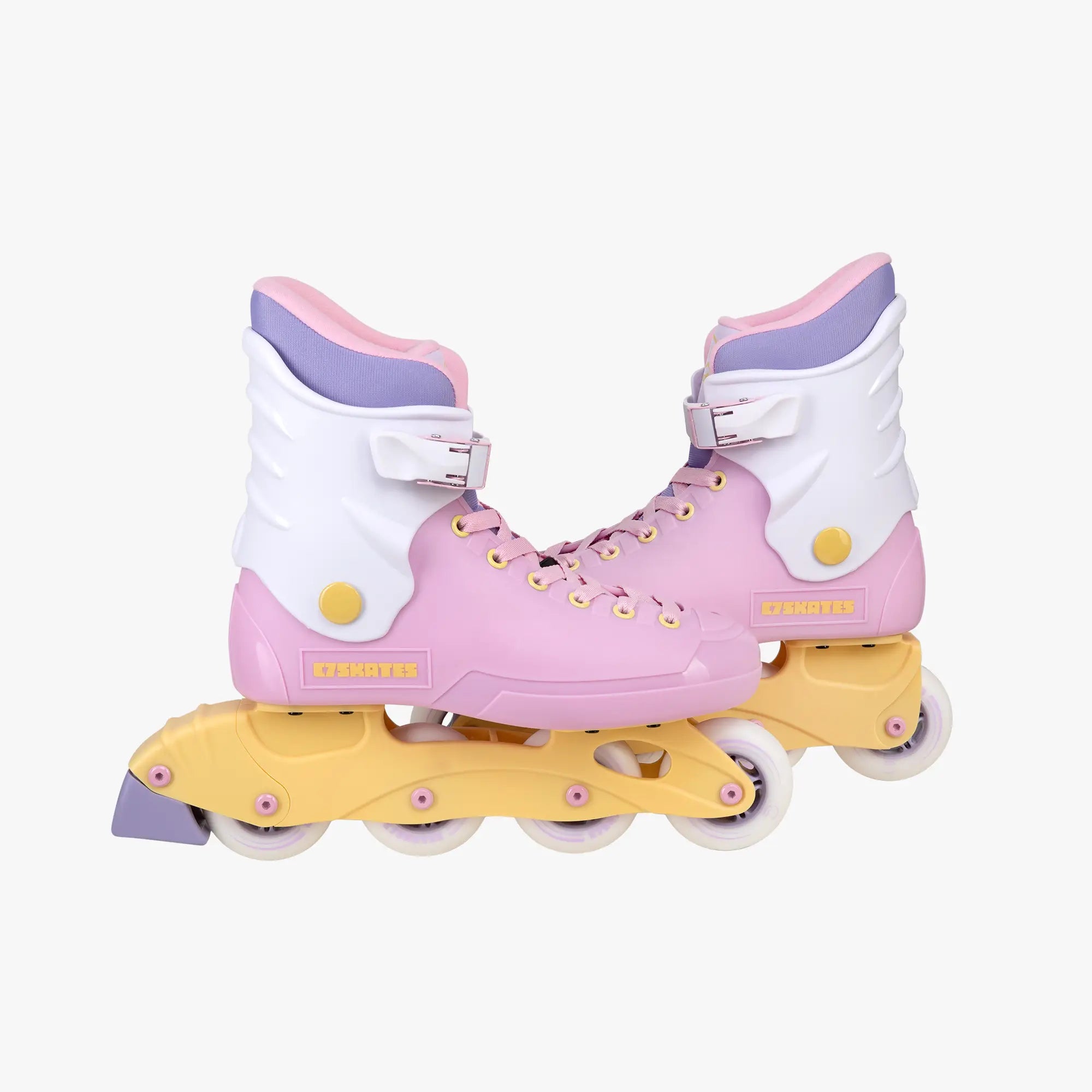 Pastel pink and yellow roller skates on a white background