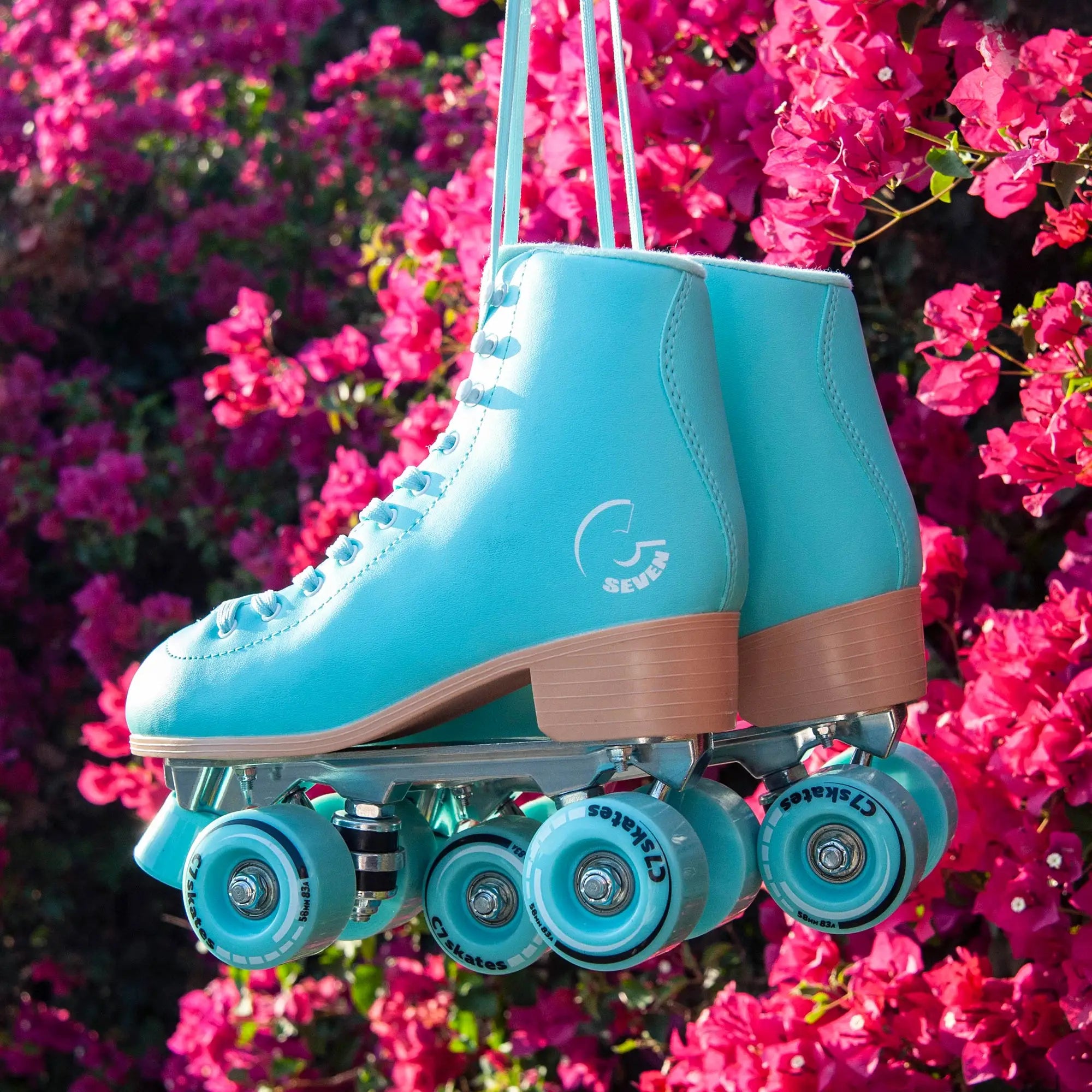 Turquoise roller skate with brown accents hanging against a pink floral background