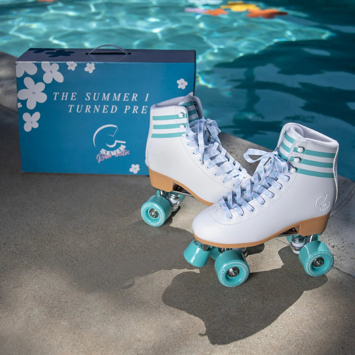 White roller skates with turquoise wheels next to a blue box by a pool