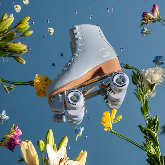 Roller skate with wooden toe cap surrounded by flowers against a blue sky