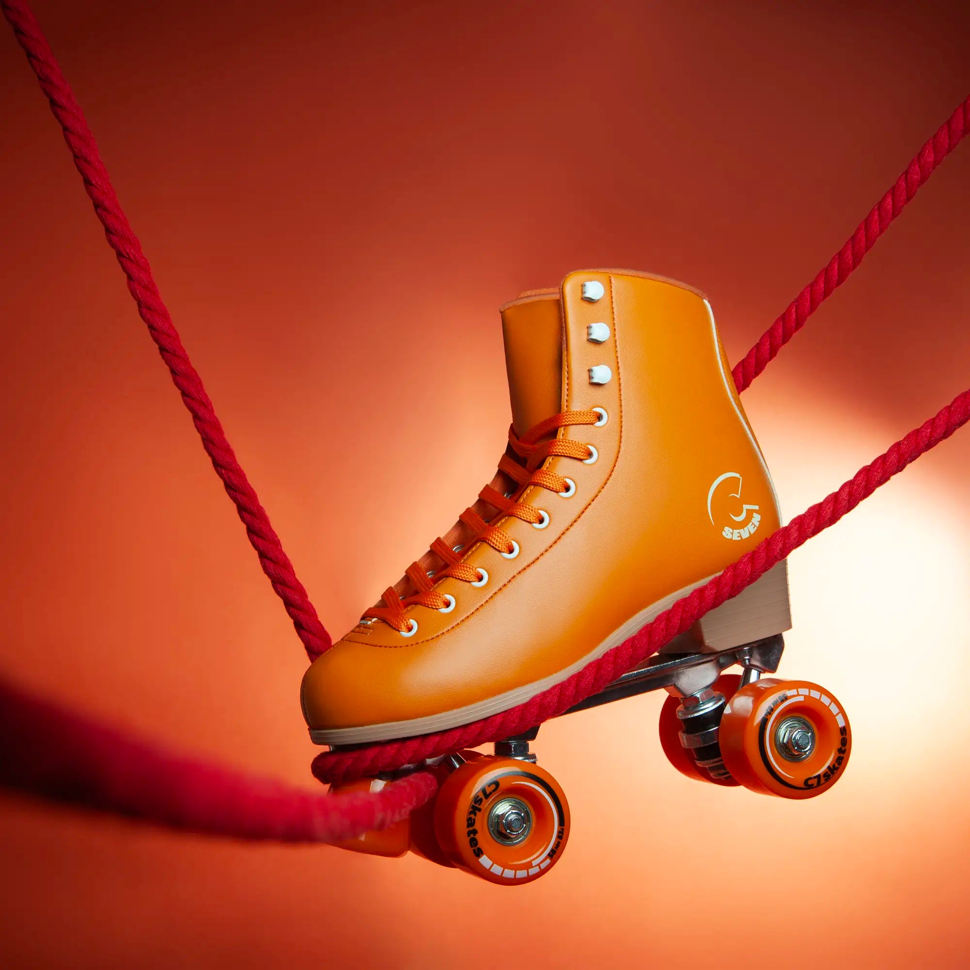 Orange roller skate with red shoelace on a gradient background featuring the brand 'C7Skates'