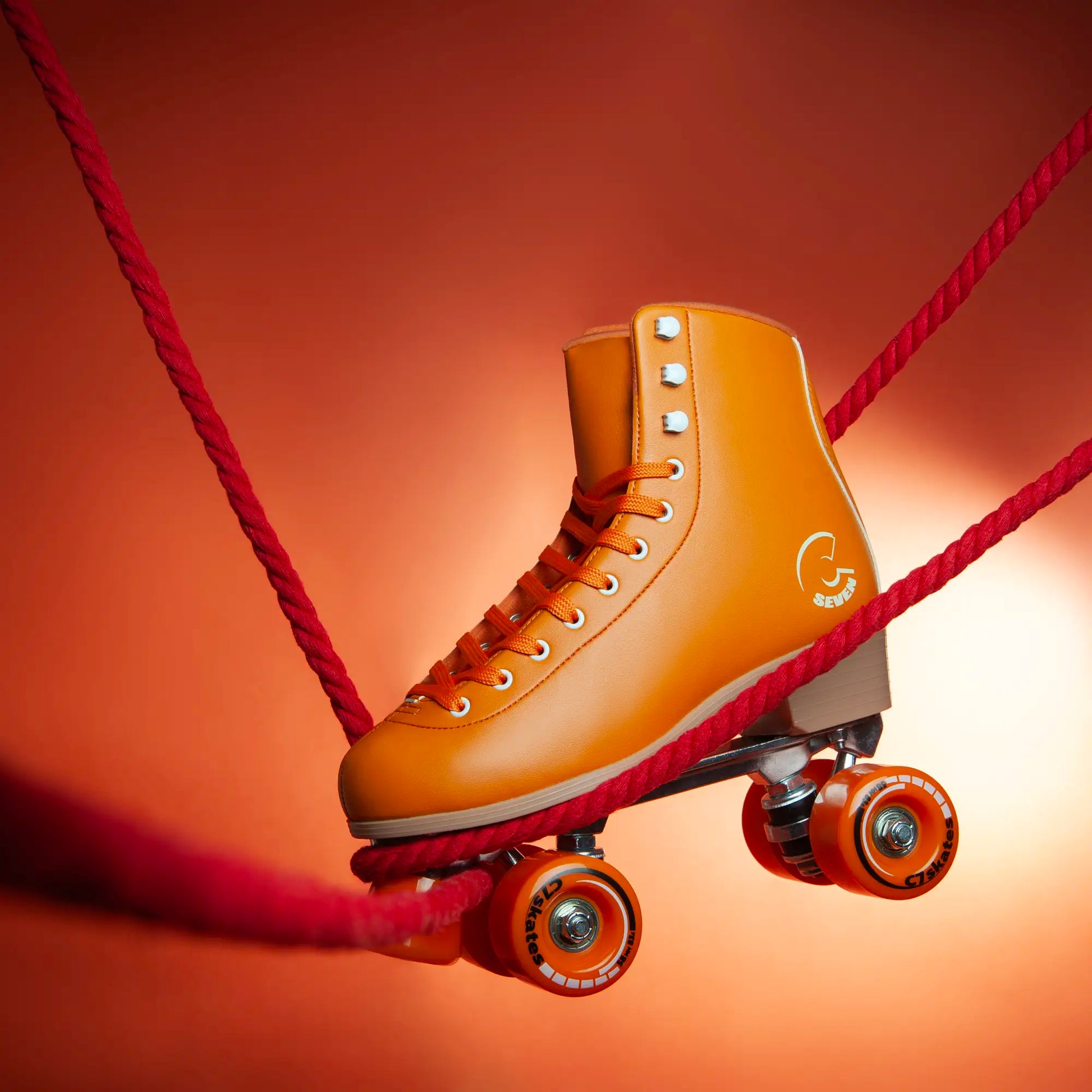 Orange roller skate with red shoelace on a gradient background featuring the brand 'C7Skates'