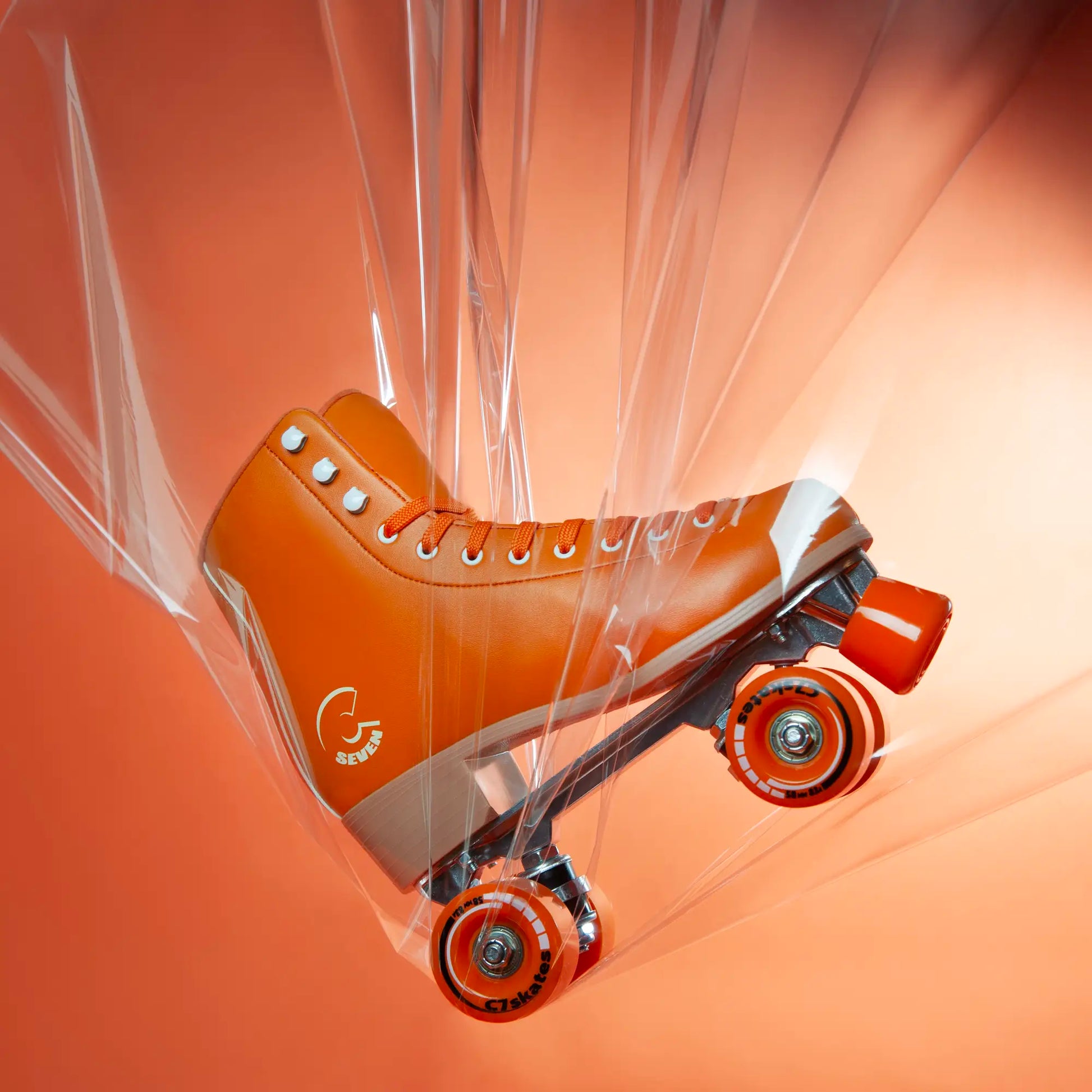 Orange roller skate with clear ribbon on an orange background featuring the brand 'C7Skates'