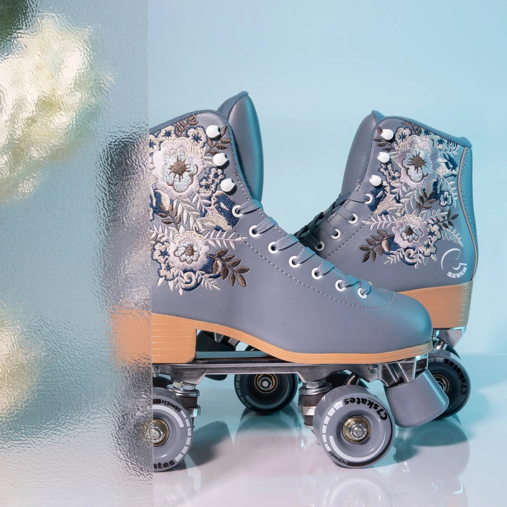 Gray floral-patterned roller skates on a light blue background