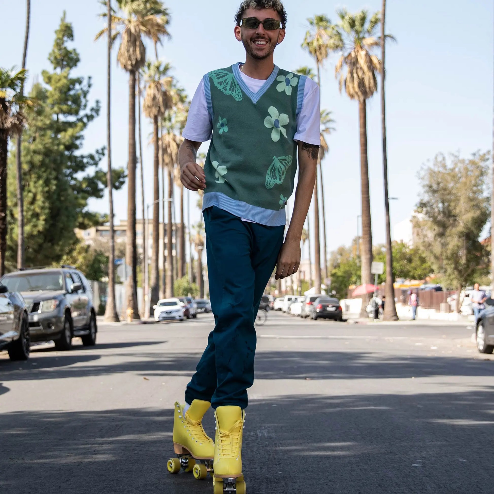 Man rollerblading on a street with palm trees in the background