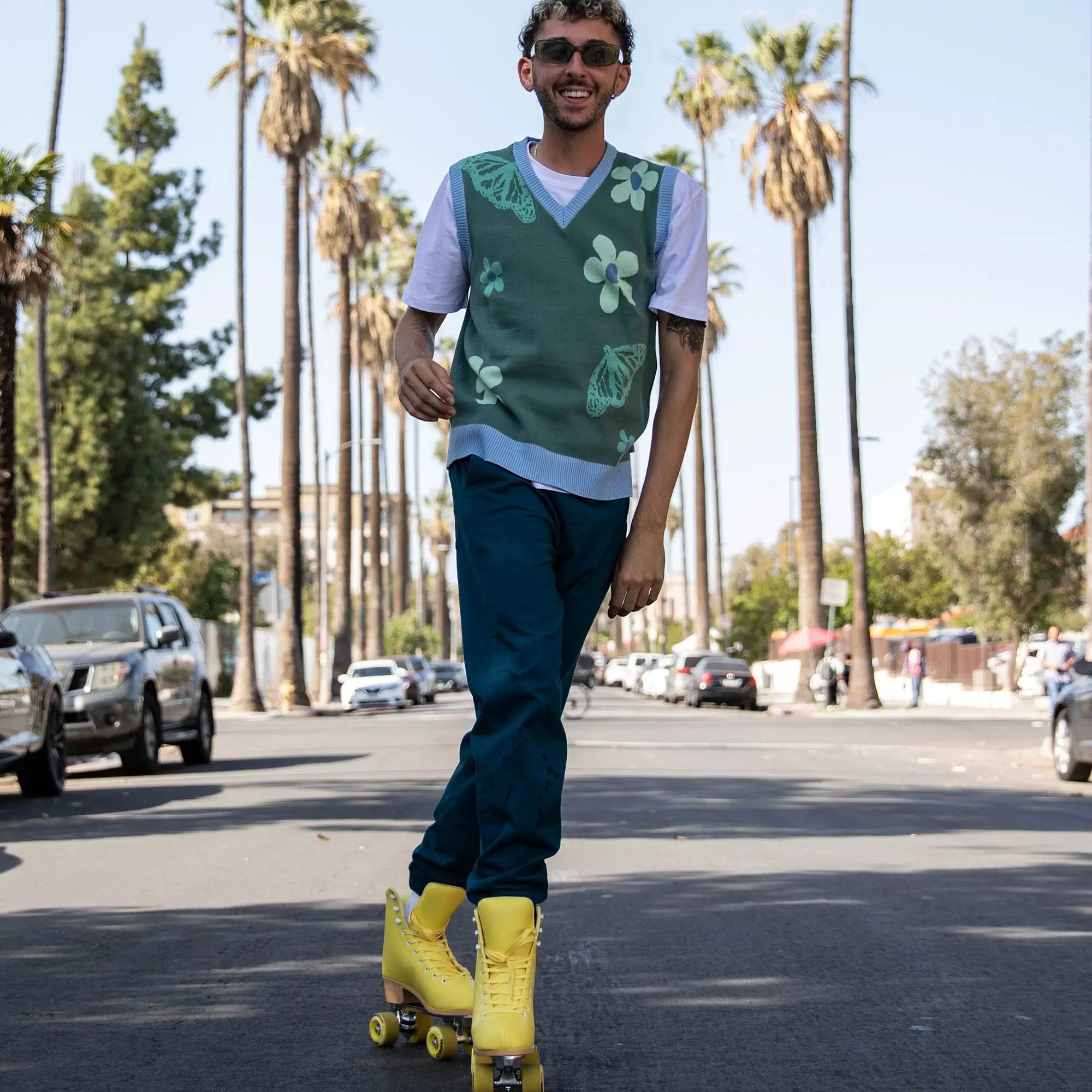 Man rollerblading on a street with palm trees in the background