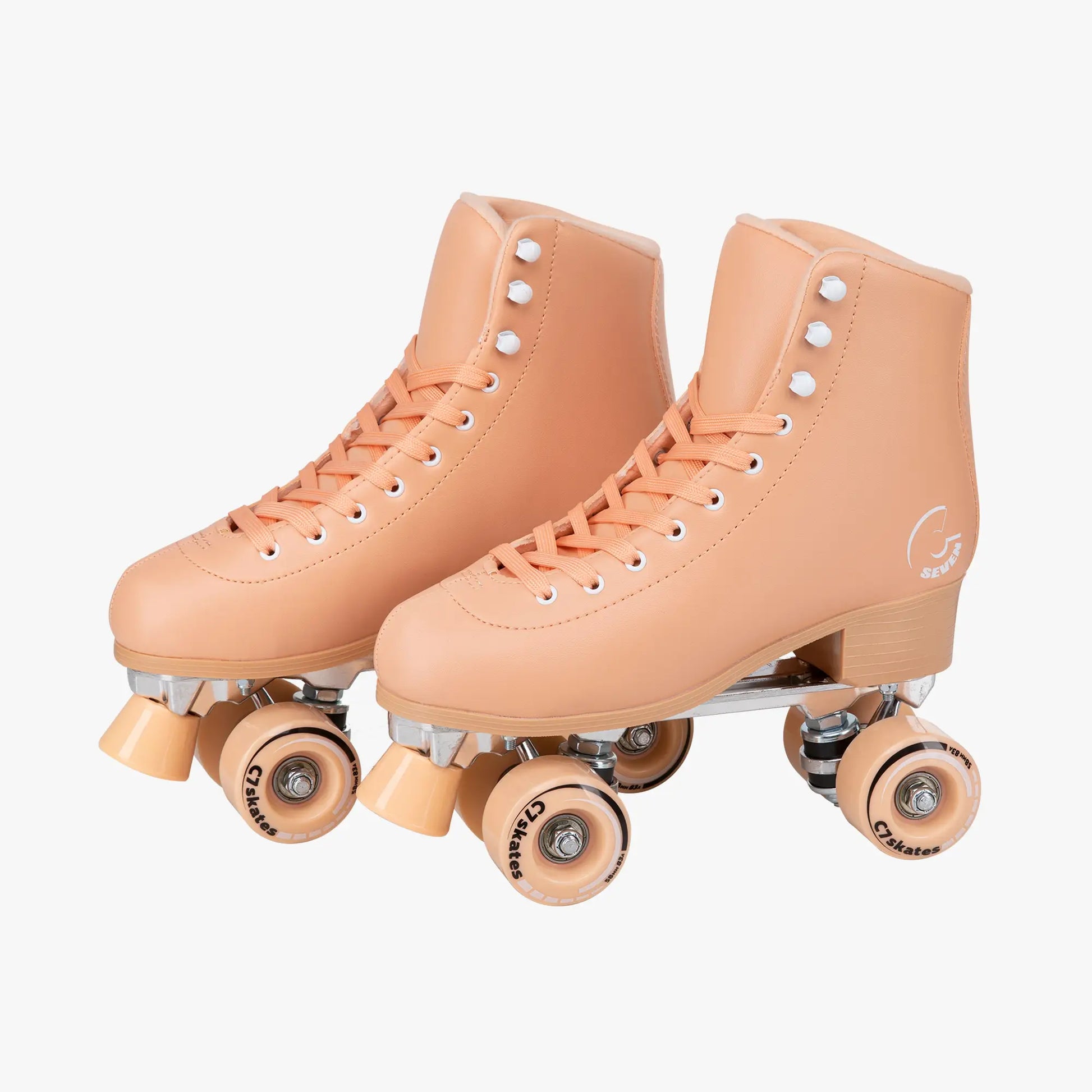 Pair of peach-colored roller skates on a white background