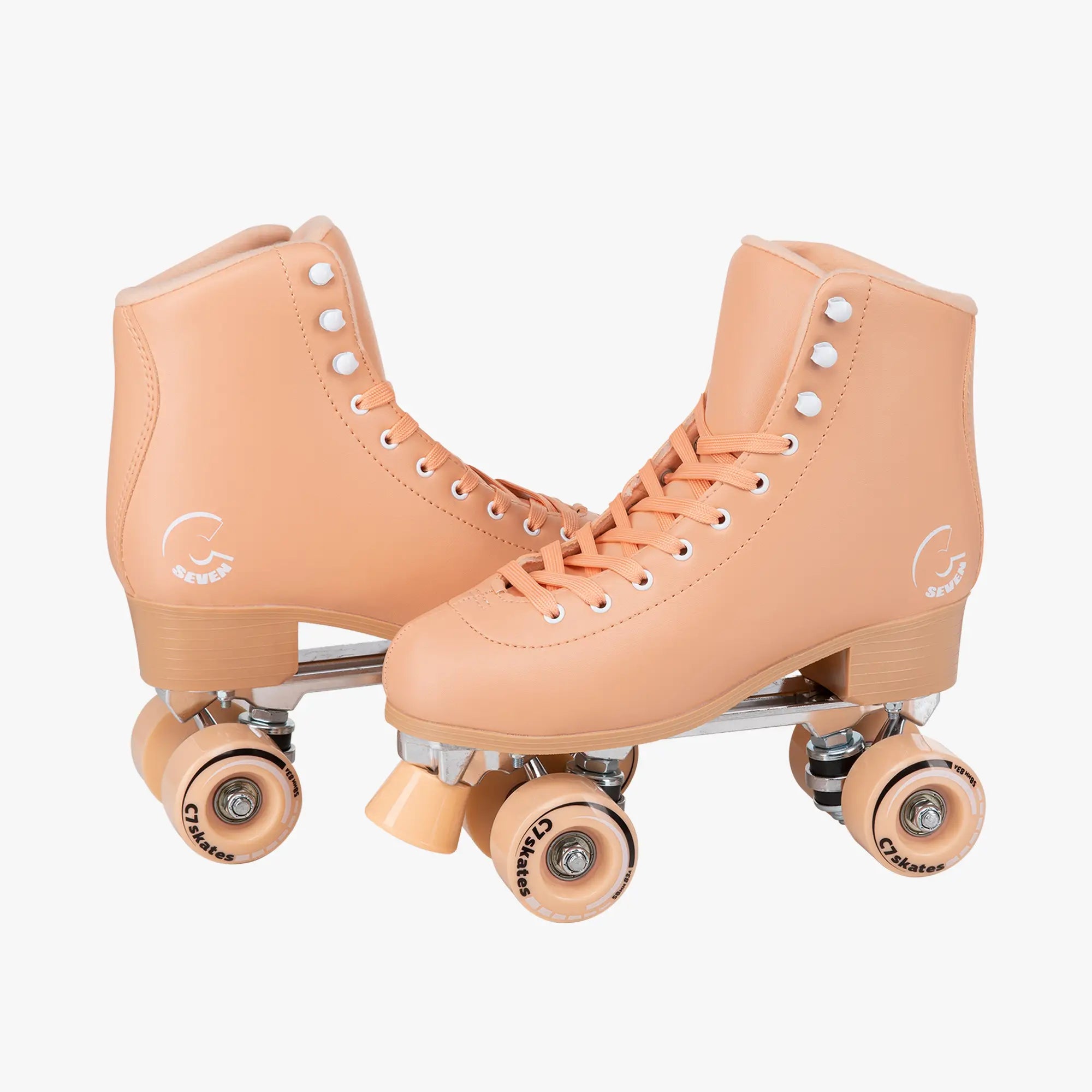 Pair of peach-colored roller skates on a white background