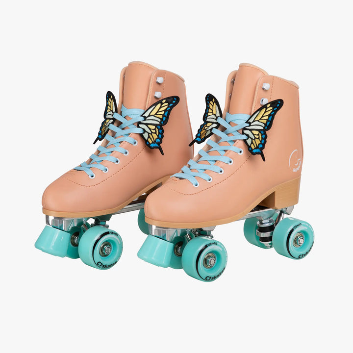 Pair of peach roller skates with butterfly decorations and turquoise wheels on a white background
