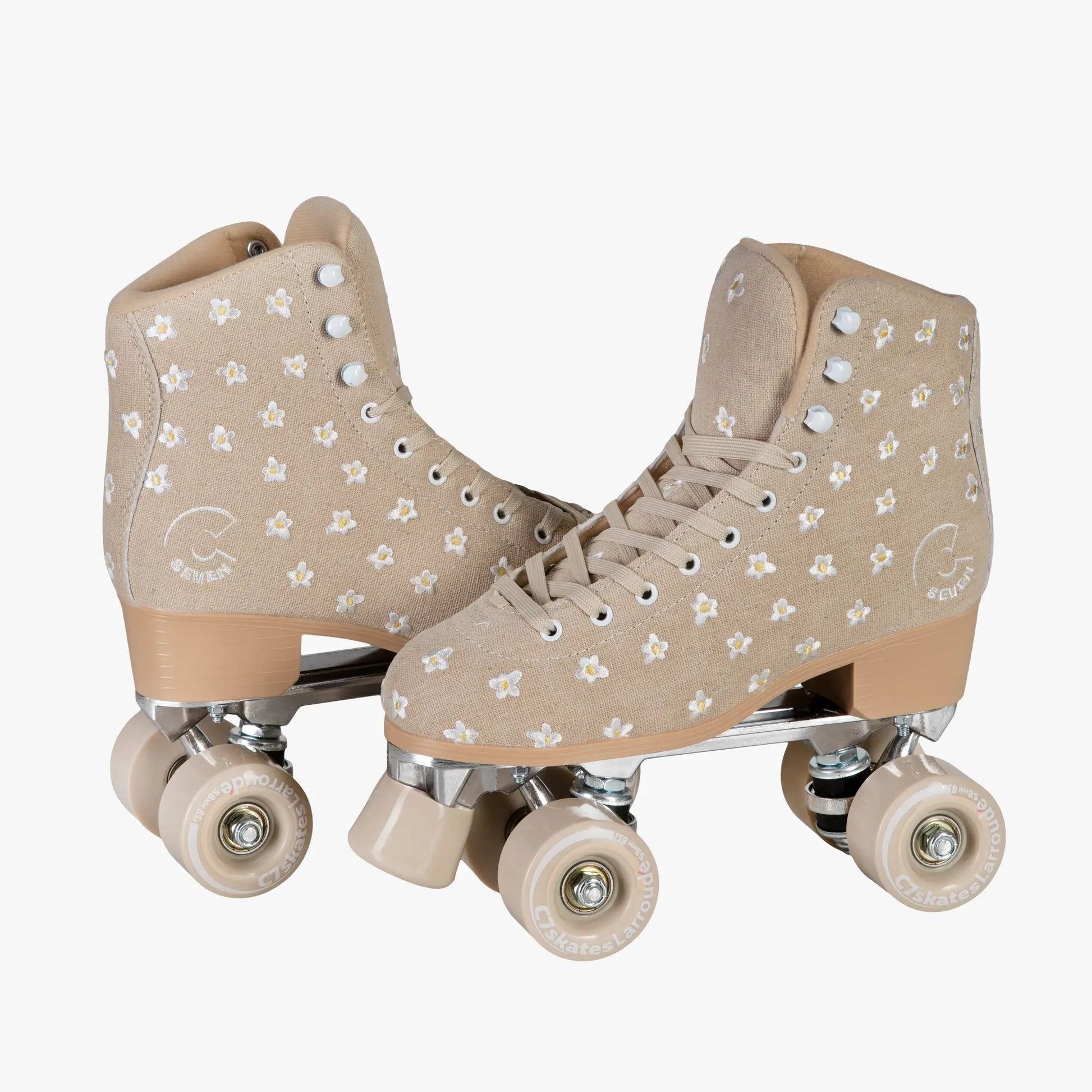 Pair of beige roller skates with star pattern on a white background