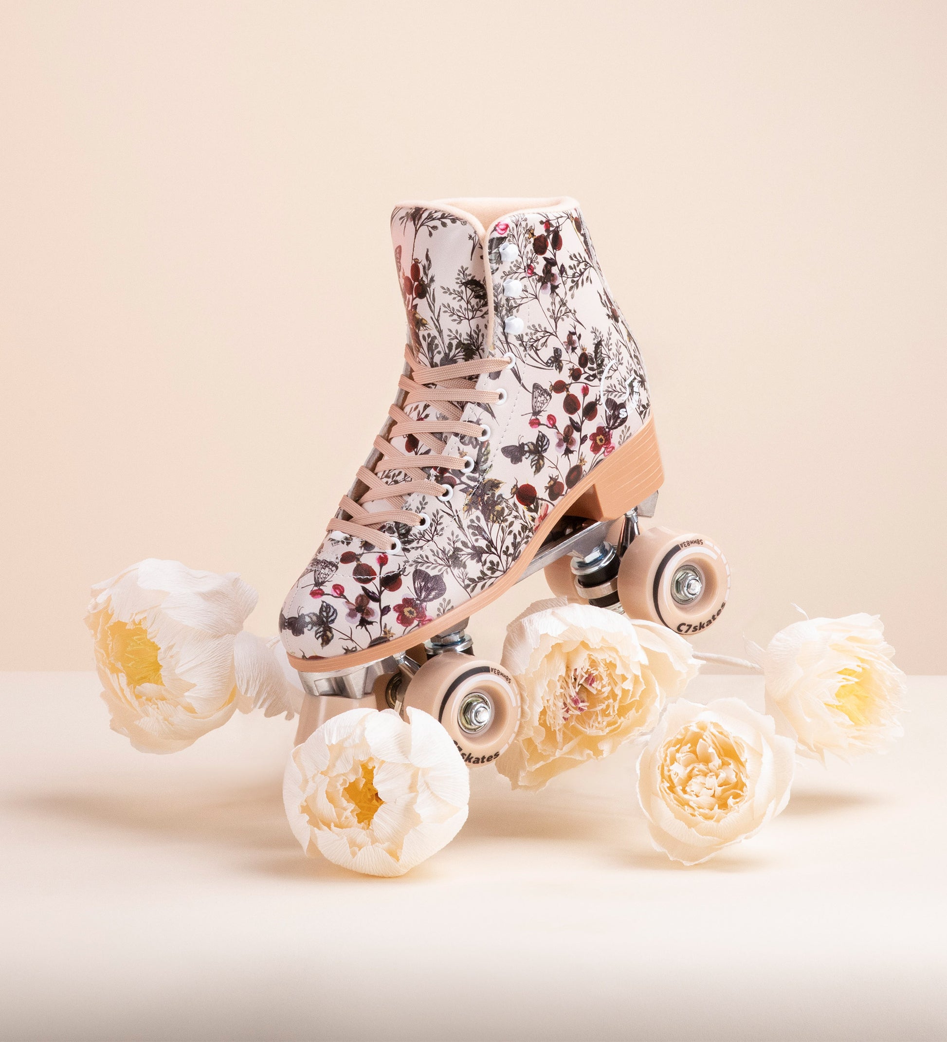 Floral-patterned roller skates with white flowers on a beige background