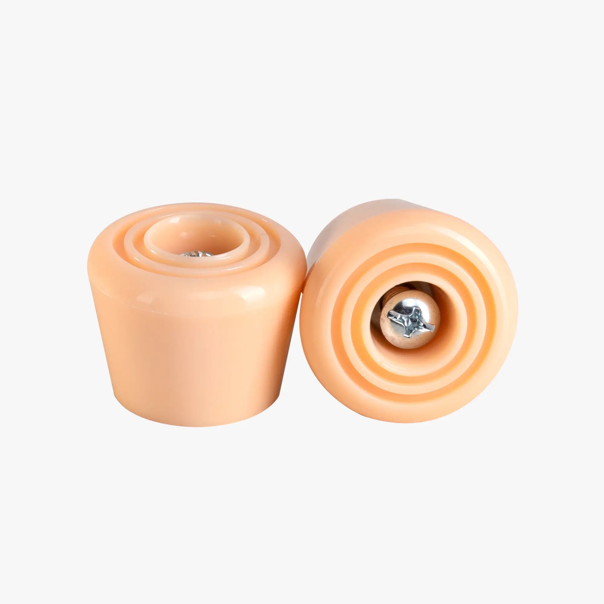Two peach-colored stoppers on a white background