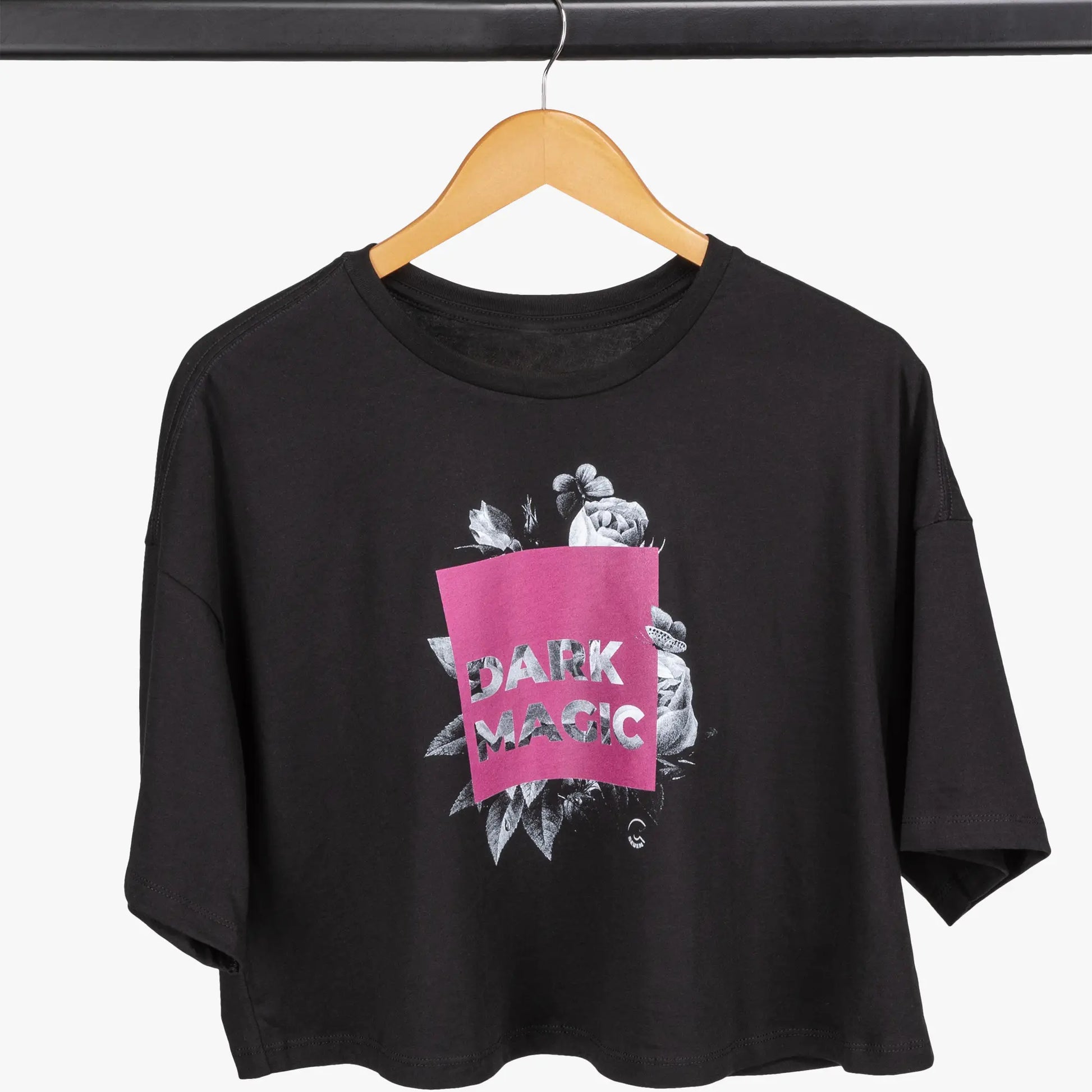 Black t-shirt with 'Dark Magic' design on a hanger against a white background