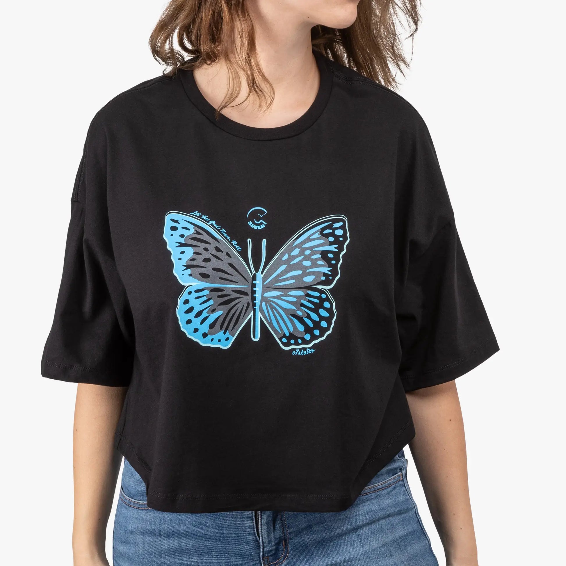 Person wearing a black t-shirt with a blue butterfly design on a plain background