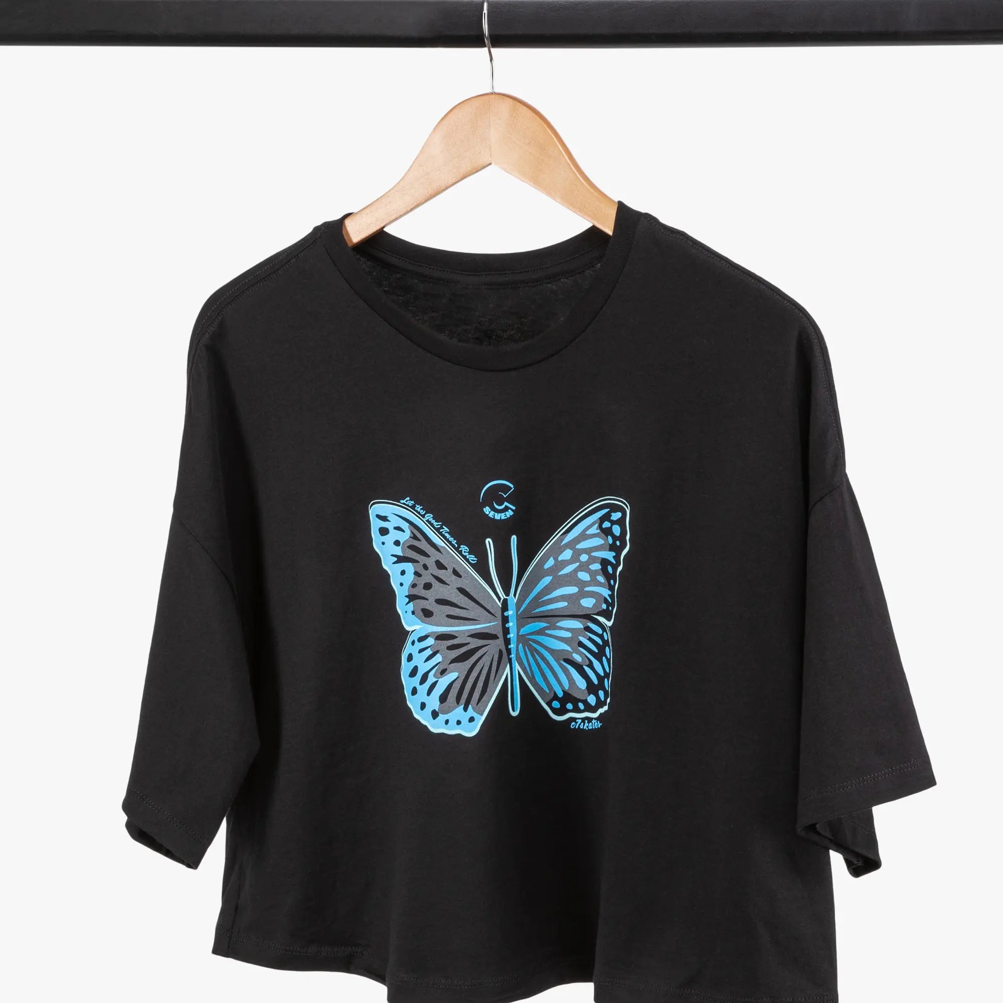 Black t-shirt with a blue butterfly design on a hanger against a white background