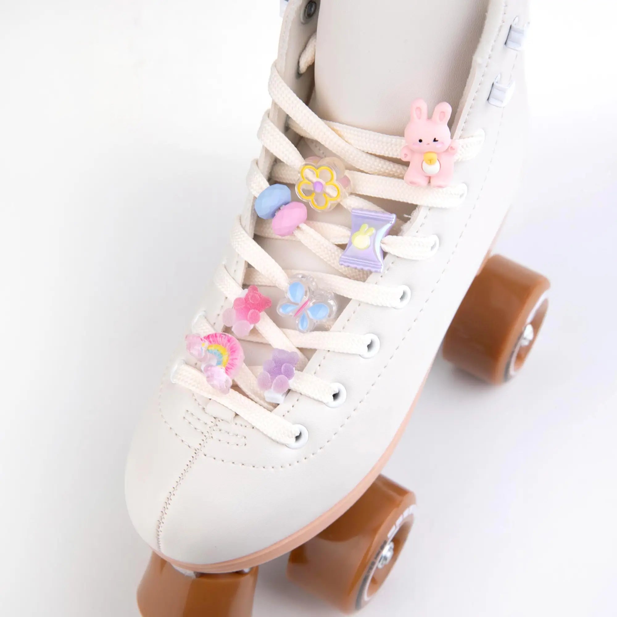 White roller skates with decorative charms on a white background