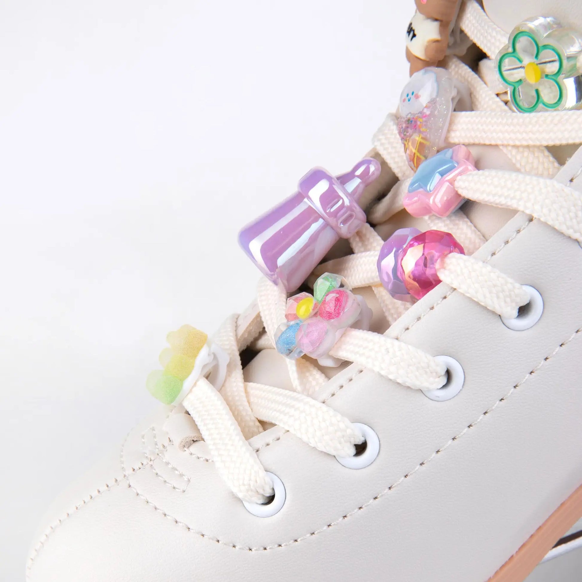 Colorful shoe charms on a white roller skates with a plain background
