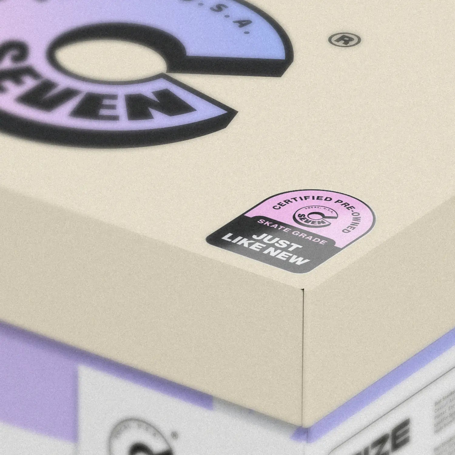 Close-up of a skateboard box with 'Seven' branding and certification label.