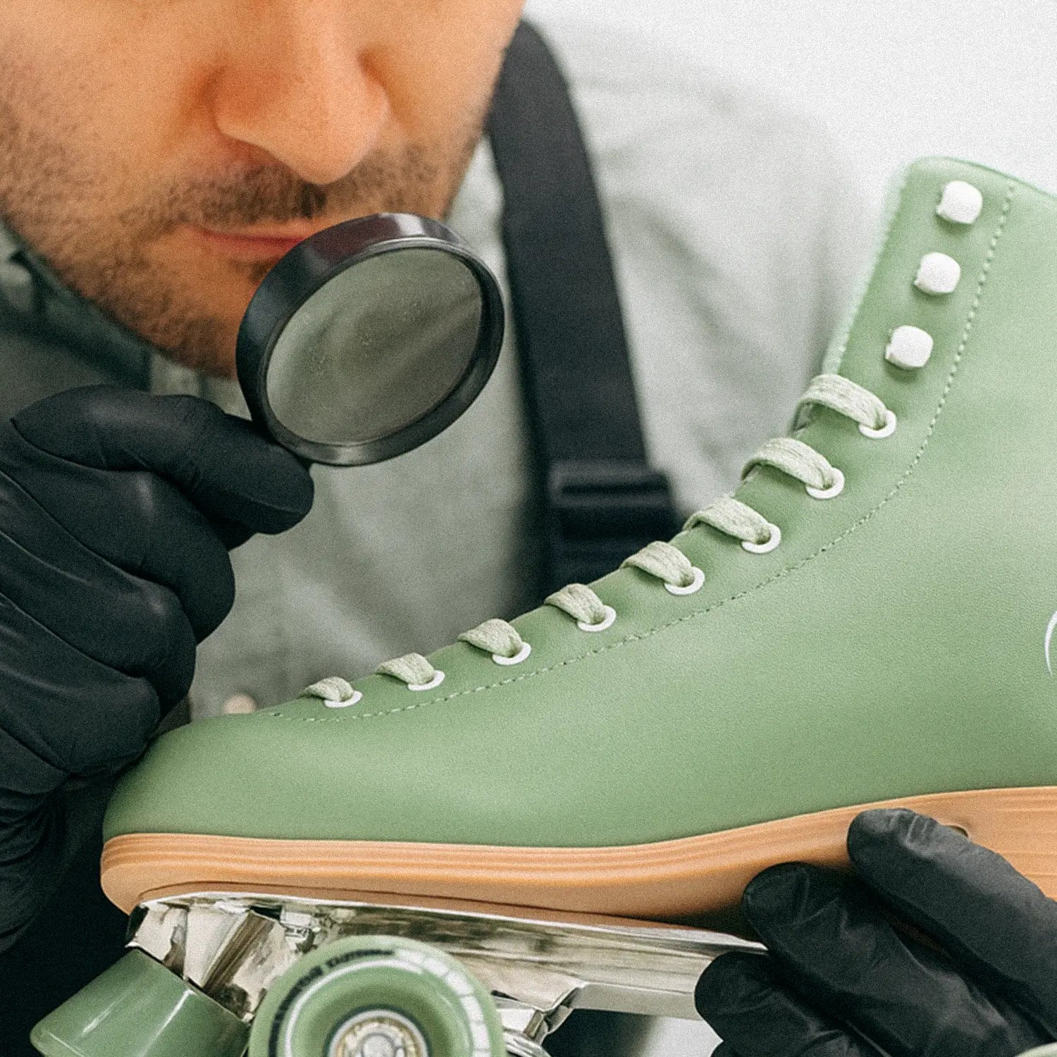 Person inspecting a green roller skate with a magnifying glass