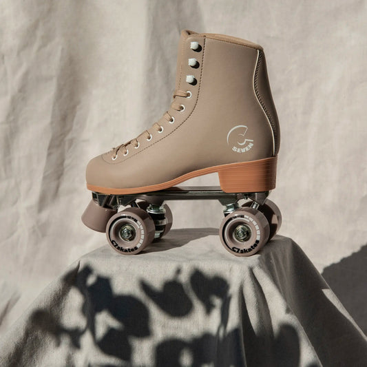 Beige roller skate with brand logo on a textured surface