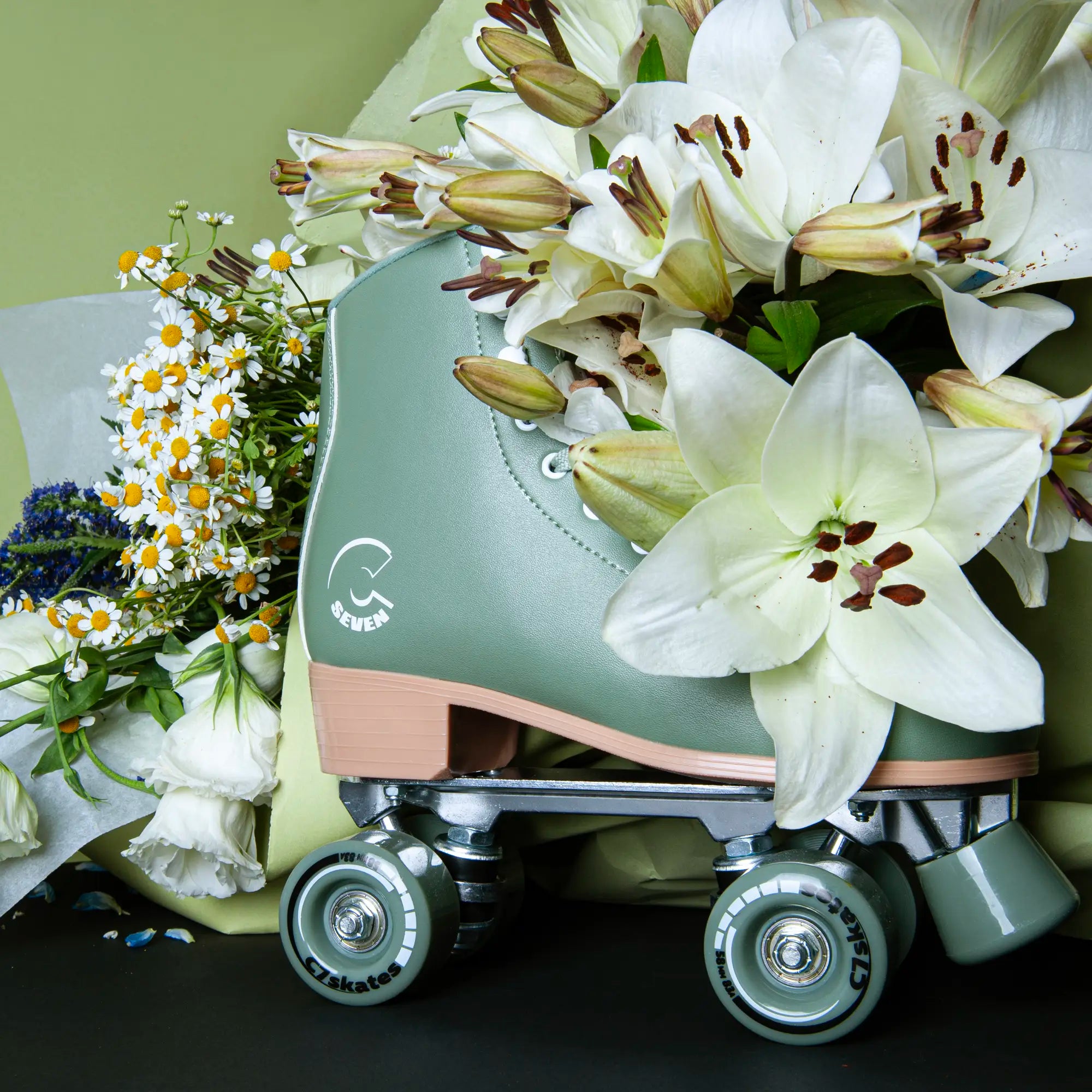 Green roller skate featuring the brand 'C7Skates' with white lilies and flowers on a dark background